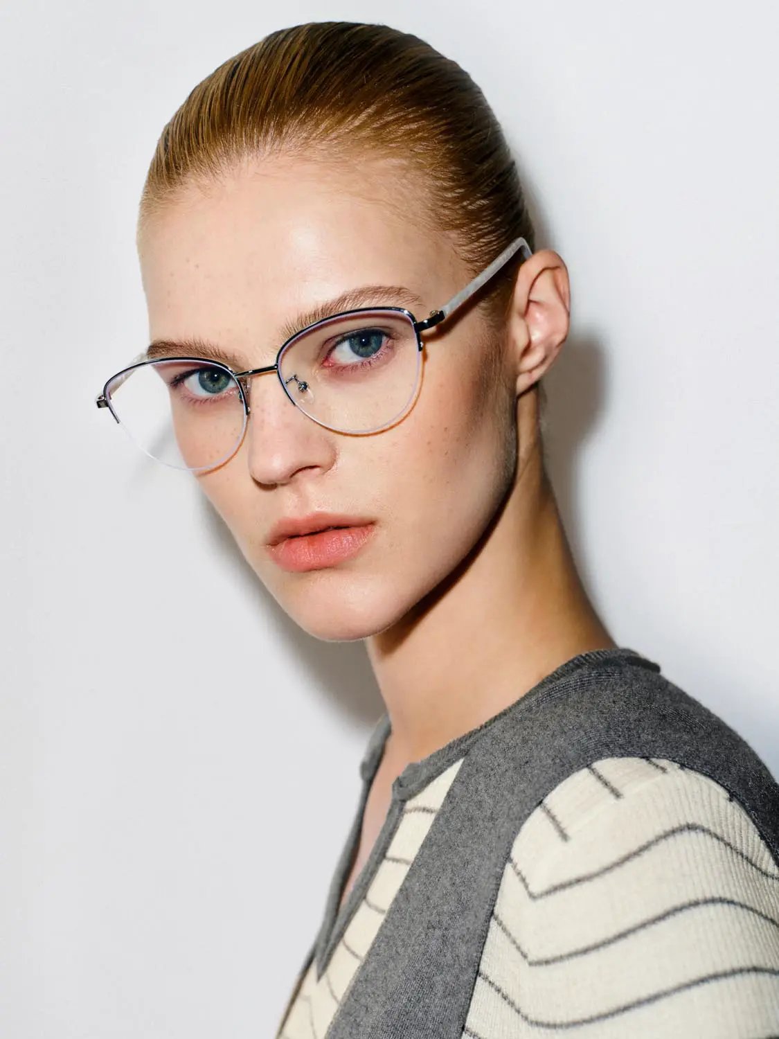 Striped shawl-knit T-shirt with a fitted V-neck and long sleeves in grey and cream, worn by a model with clear glasses