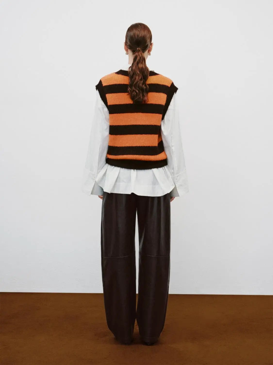 Striped stretch-knit V-neck sleeveless tank top in orange and black.