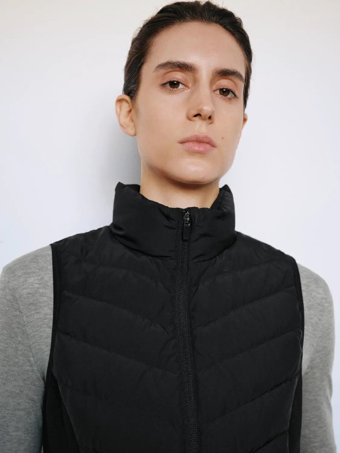 Down jacket vest; black quilted shell with front zipper.
