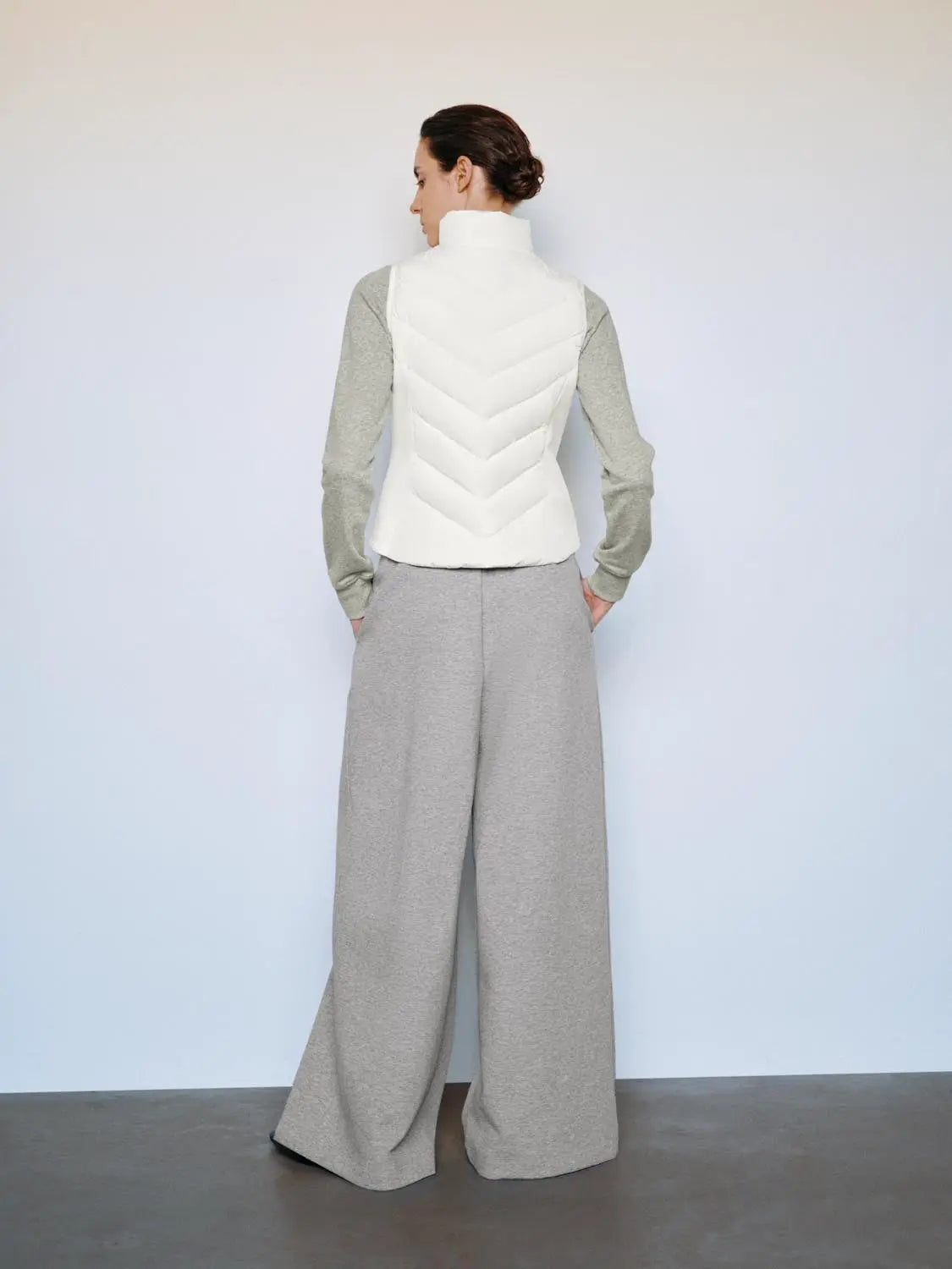 Down jacket sleeveless white with chevron quilting; Urban Revivo Fashion worn over grey sleeves and wide-leg pants.
