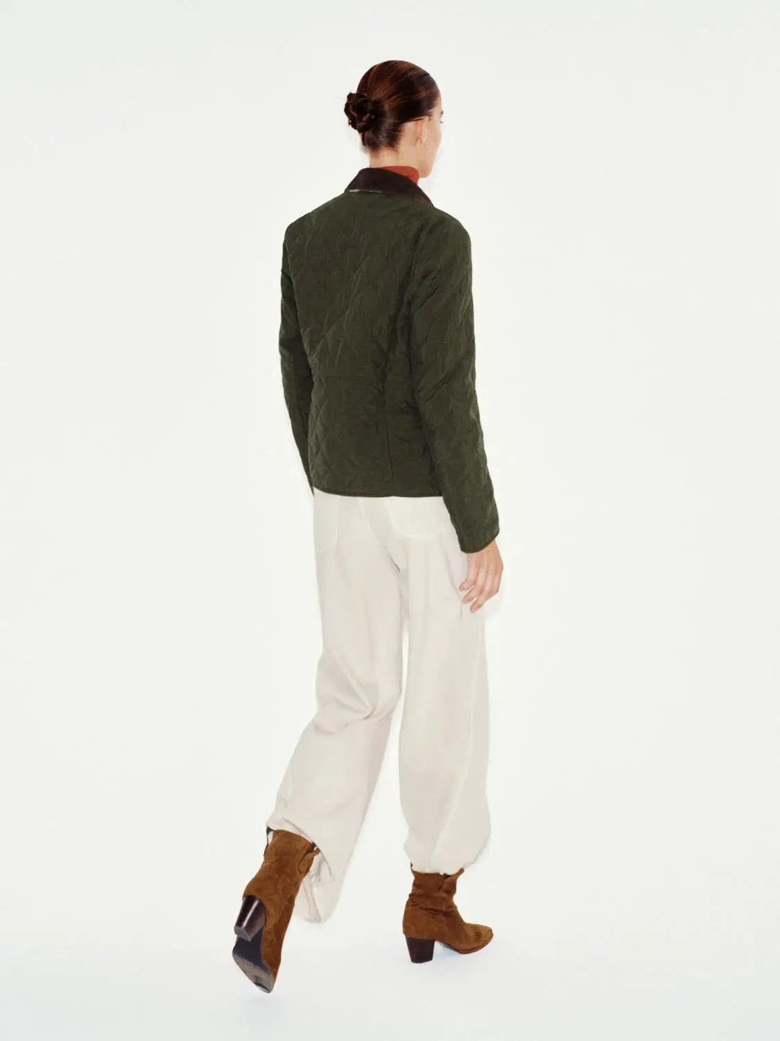 Padded jacket in olive green quilted fabric worn by model (back view).