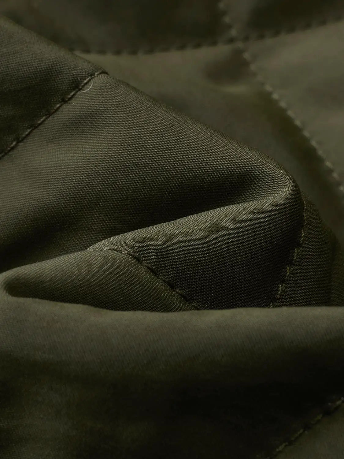 Padded jacket close-up of black fabric with visible stitching along a seam