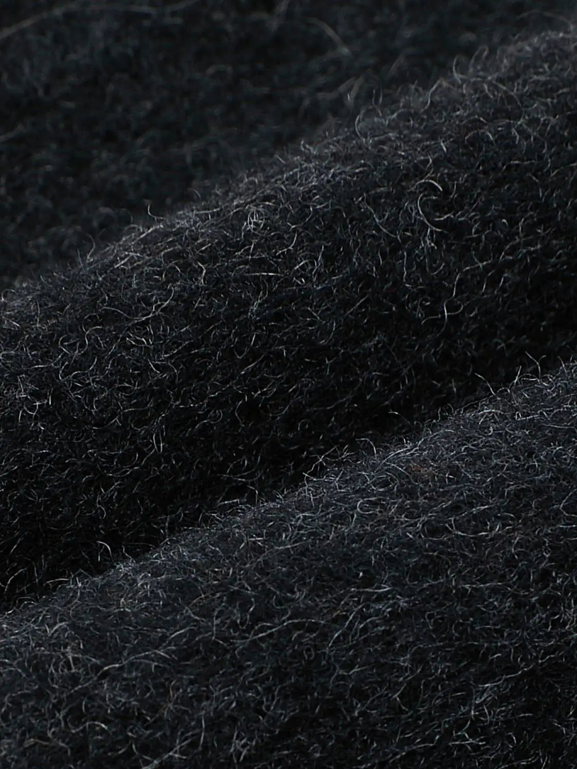 Coat black wool fabric close-up texture showing fuzzy fibers