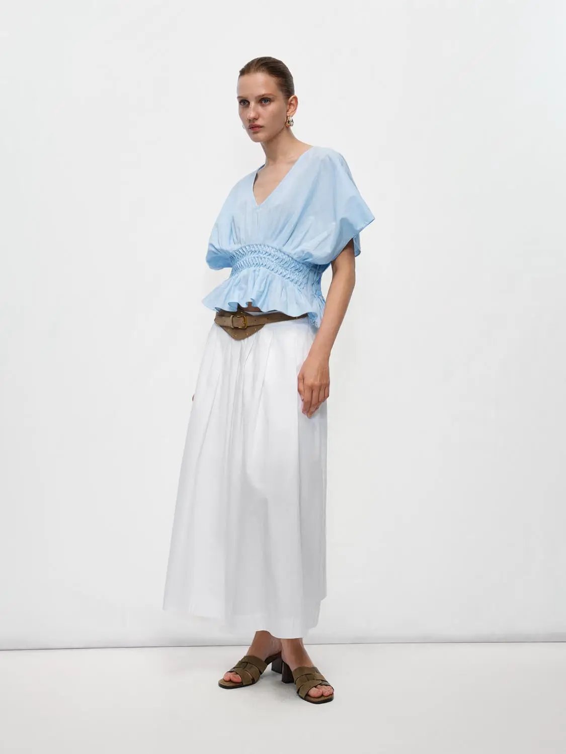 V-neck puff-sleeve blouse with smocked waist in light-blue cotton-linen blend