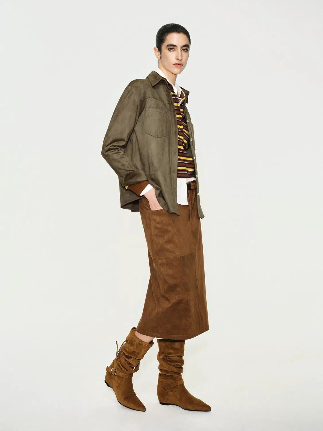 Button-down shirt in olive green, layered under a brown suede jacket with brown suede boots