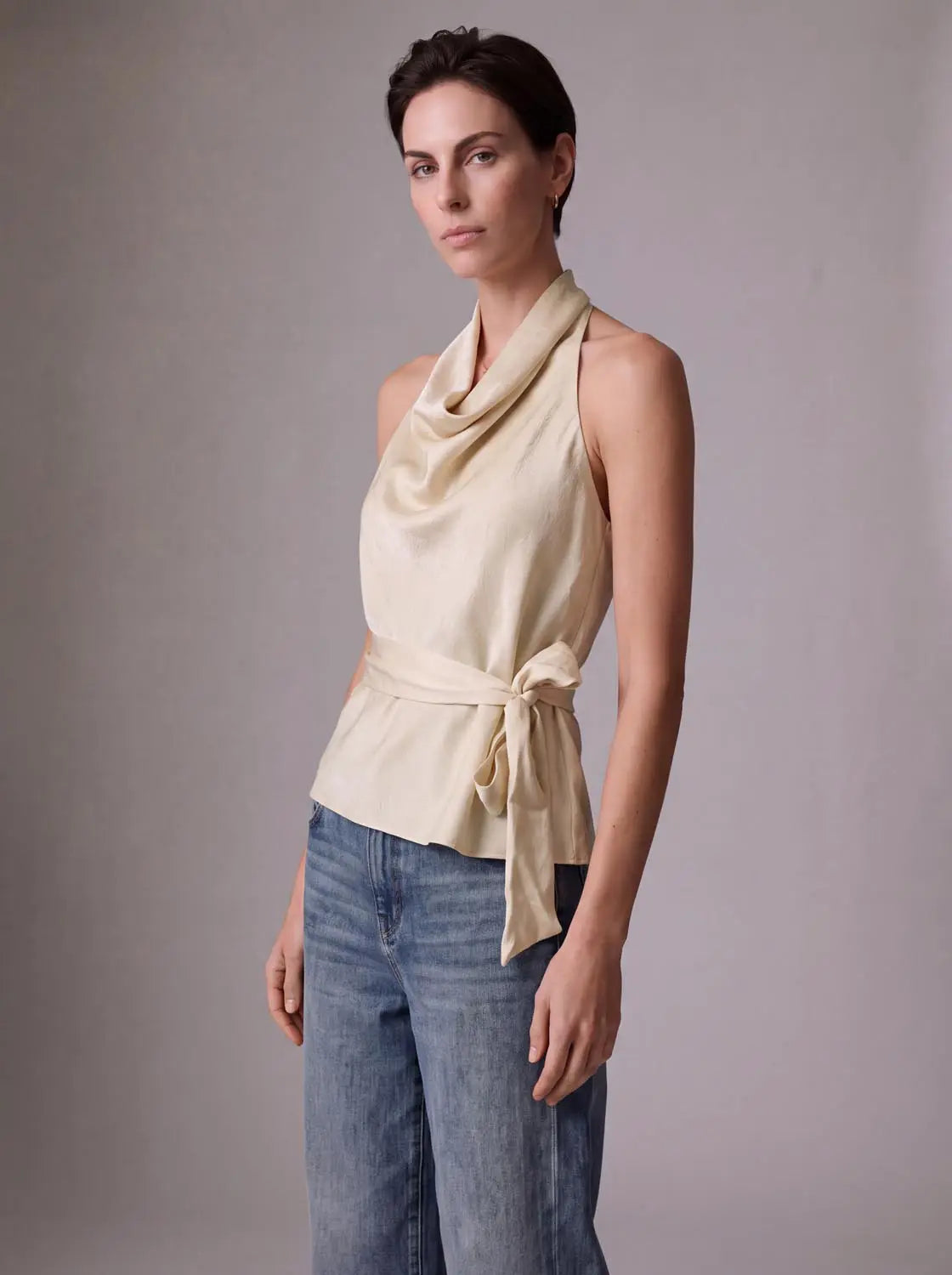 Overhead shirt, cream sleeveless with draped cowl neck and waist tie.