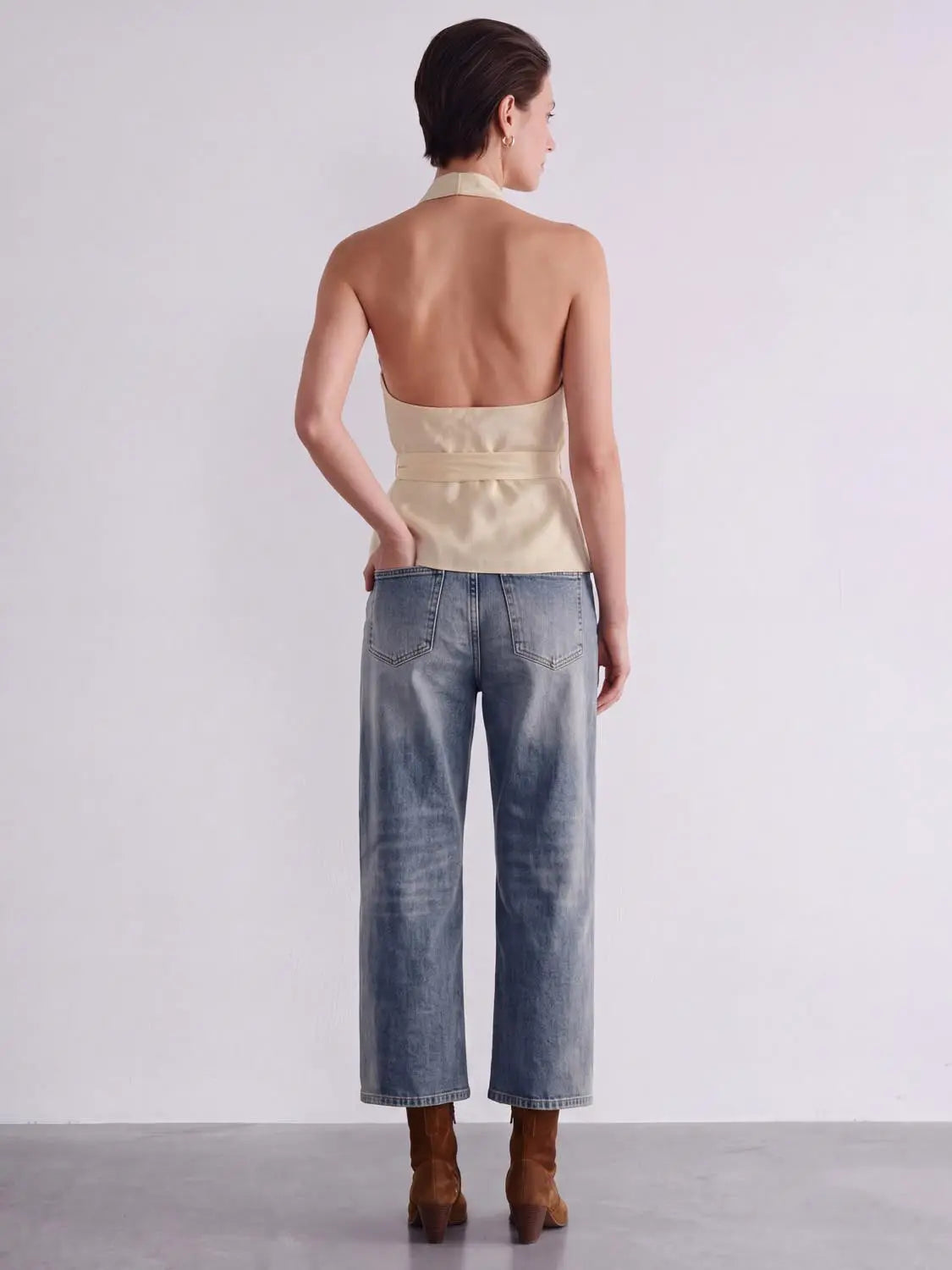 Blouse beige satin halter-neck with belted waist, back view.