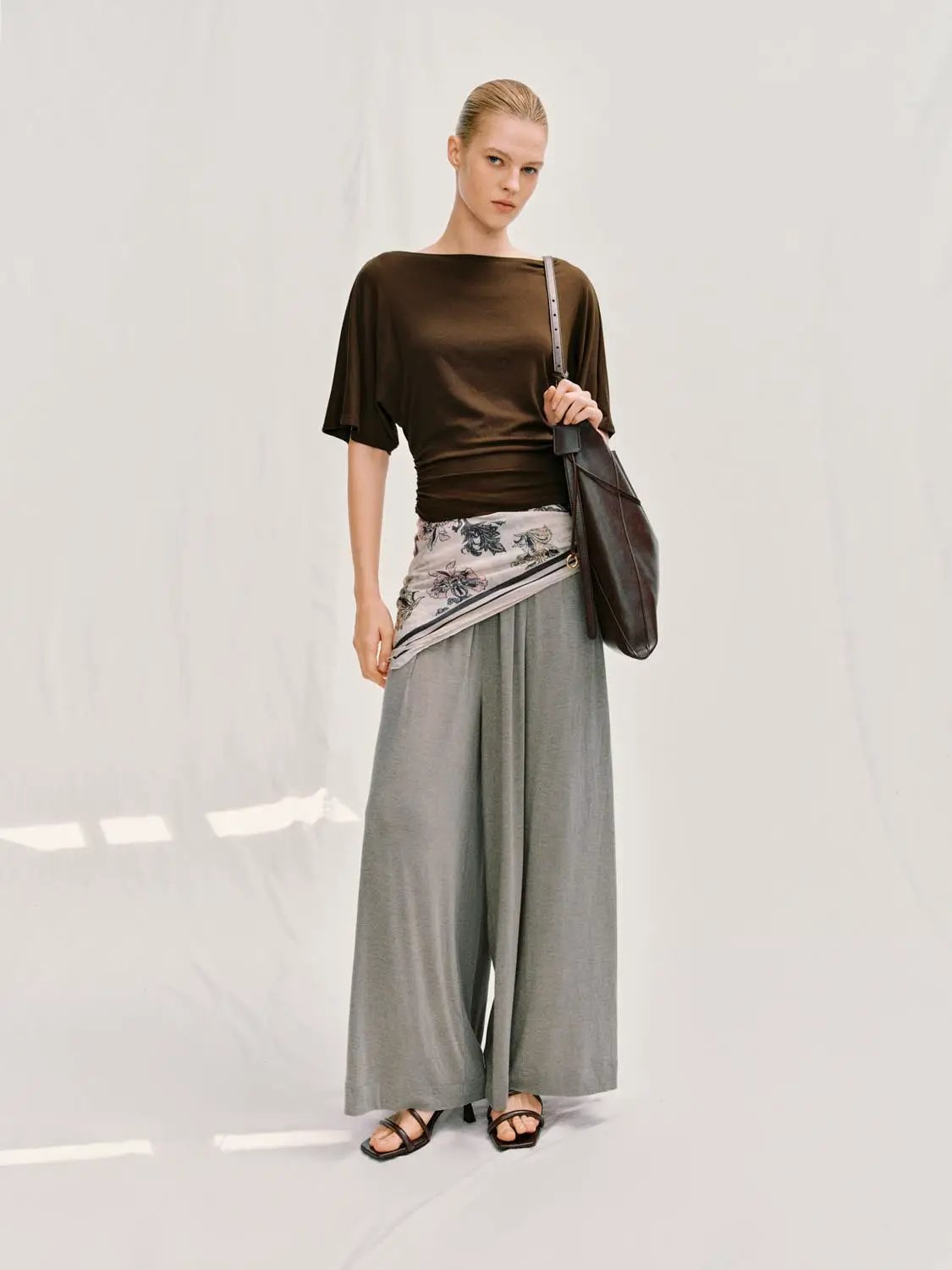 Draped Short Sleeve Ruched Waist T-shirt in brown, paired with wide-leg gray pants and a shoulder bag.