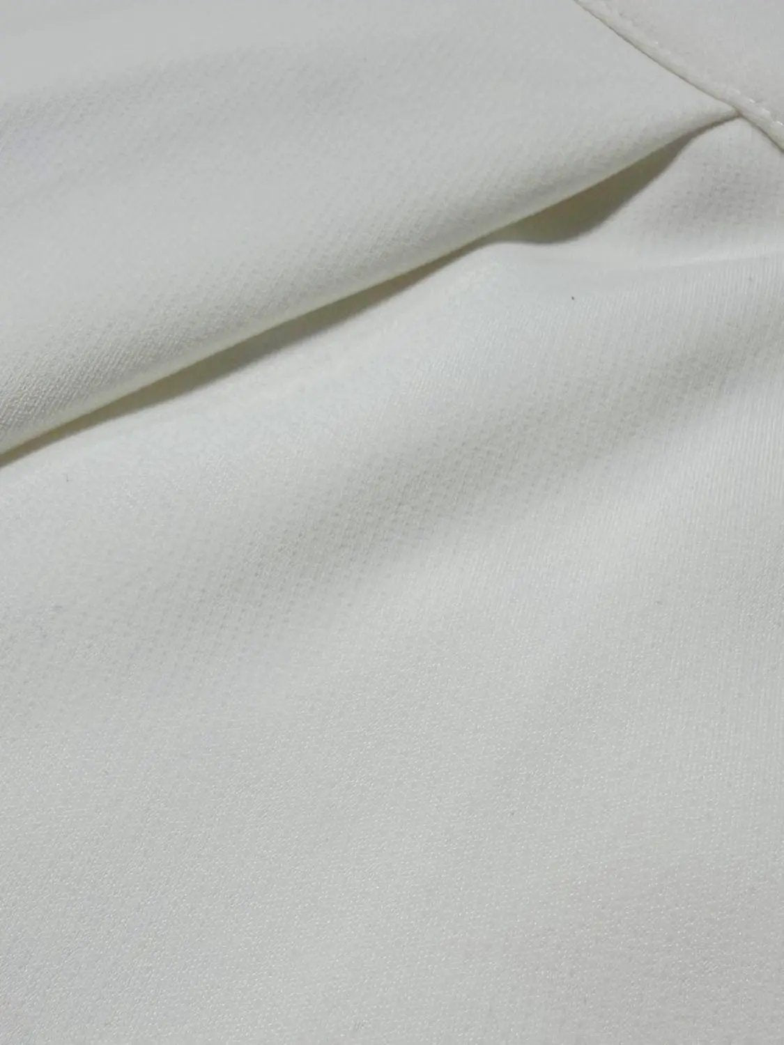 Wide-leg pants, white fabric close-up showing smooth weave and seam detail