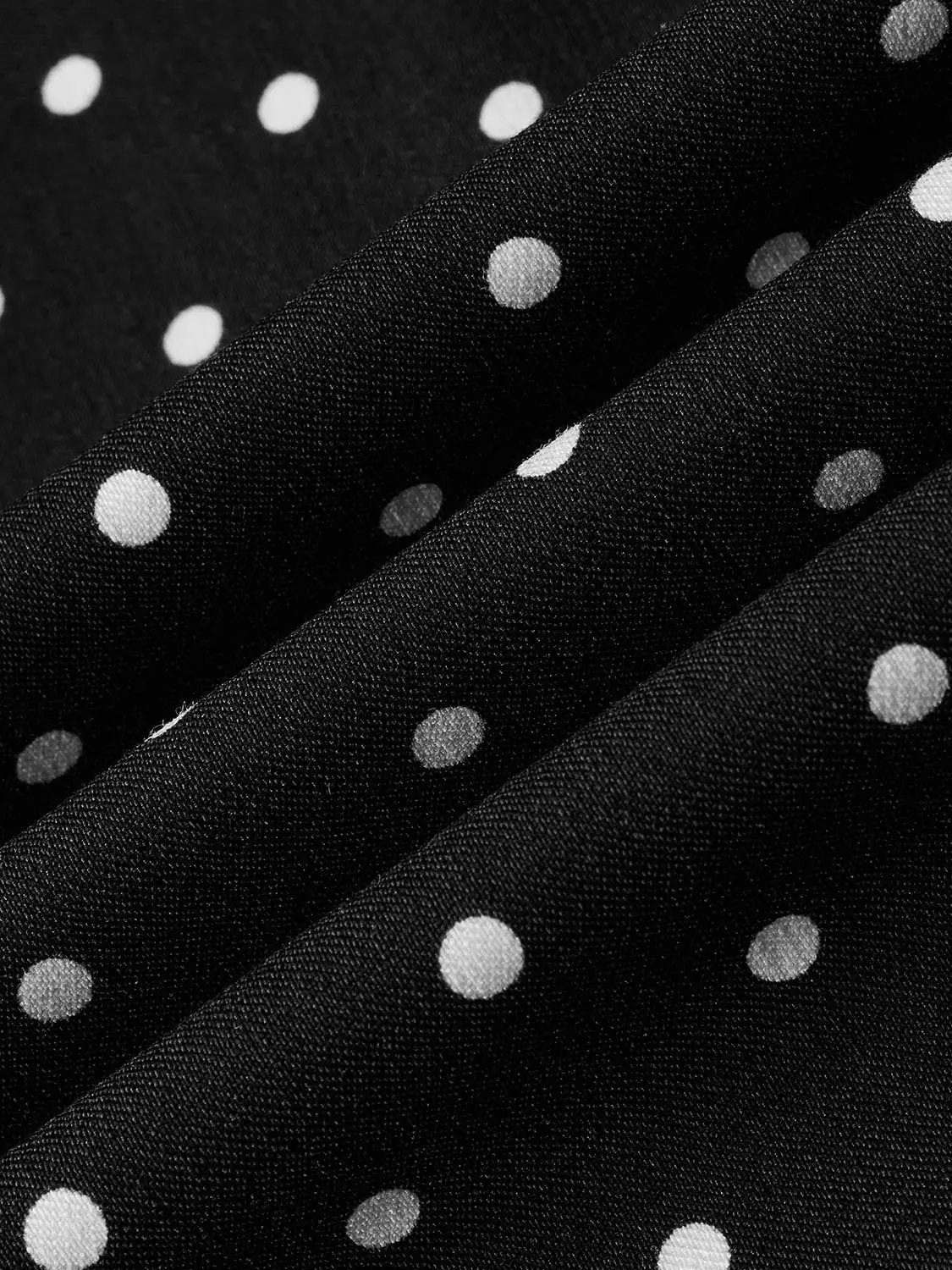 Polka dot knit sleeveless A-line dress in black with white dots.