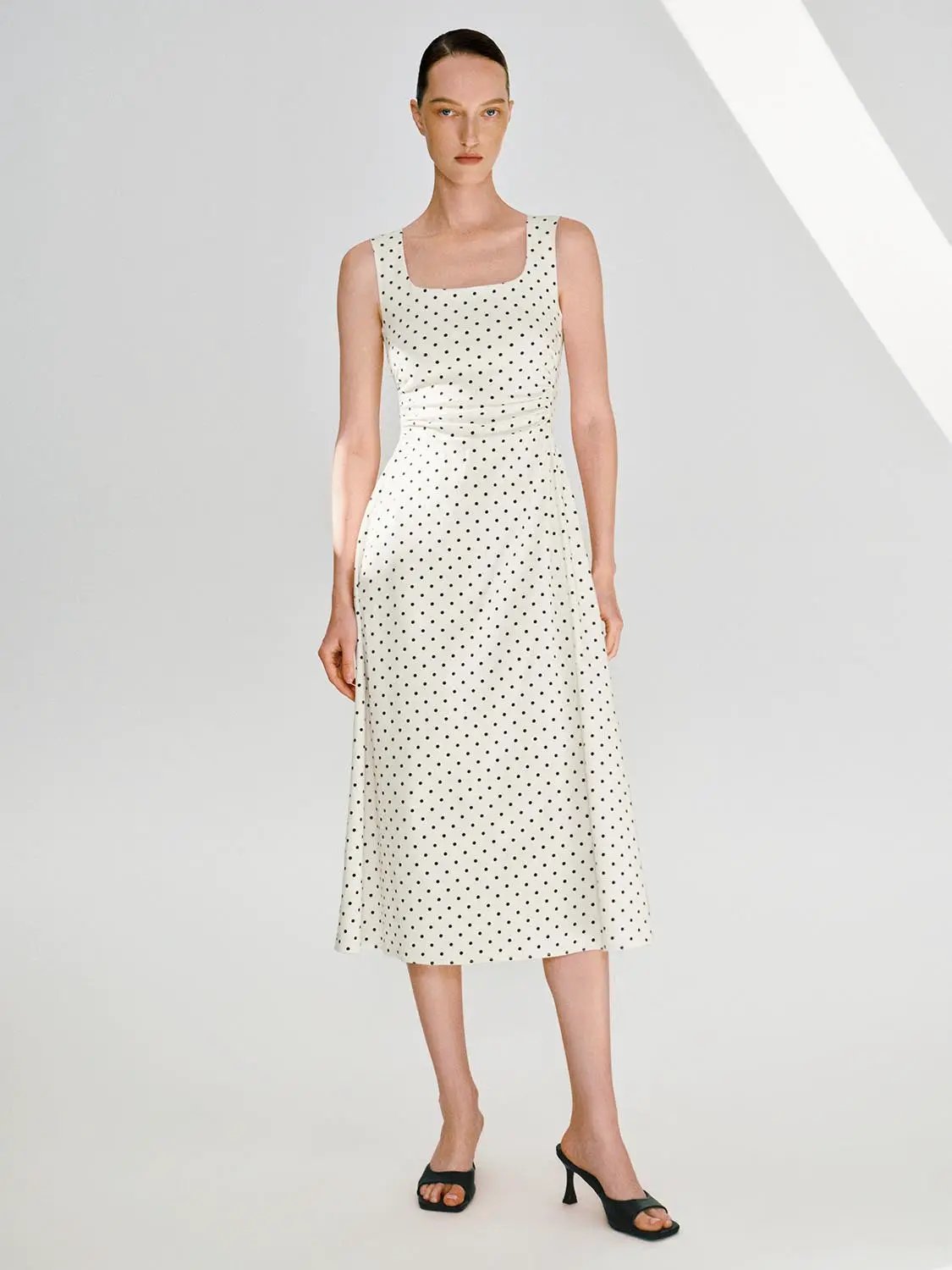 Polka dot knit sleeveless A-line dress, cream with black dots, midi length.