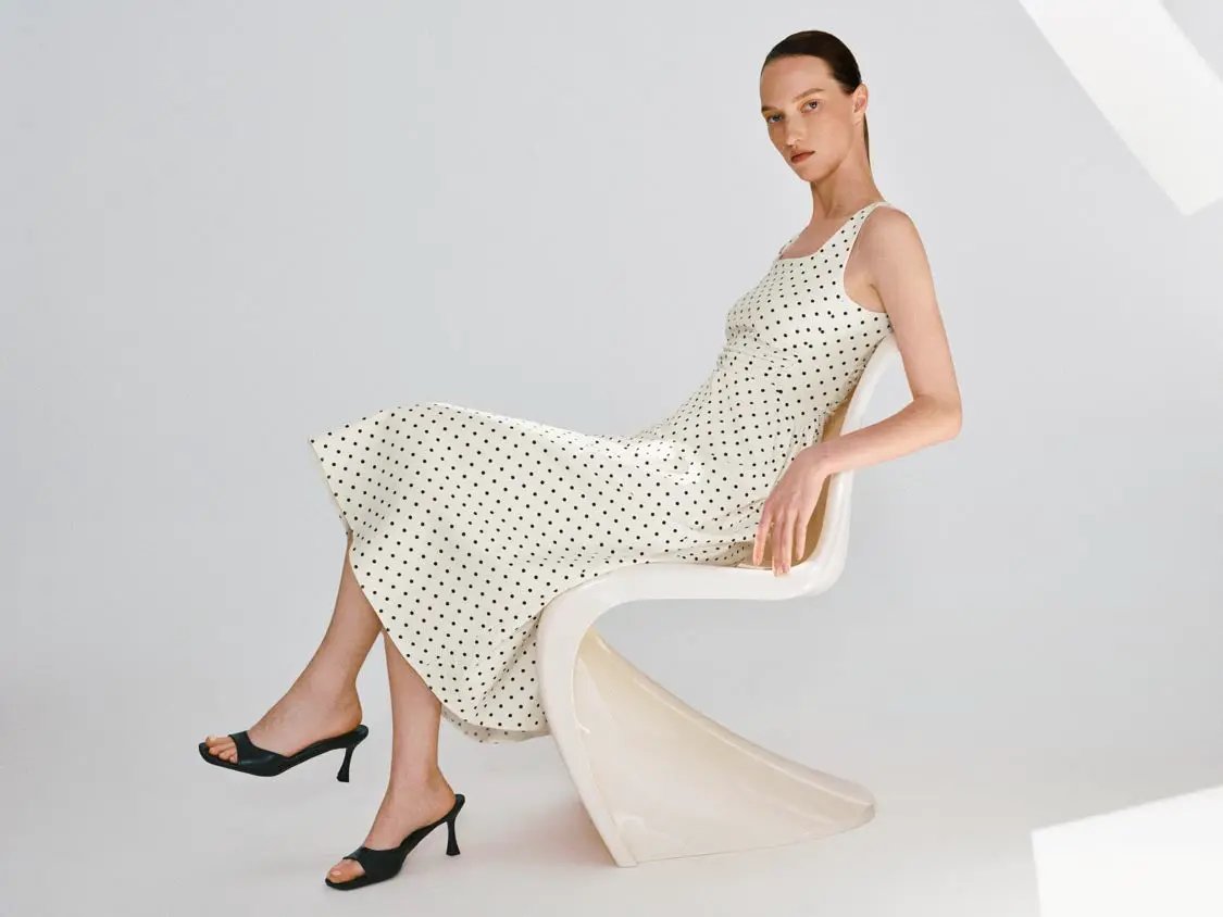 Polka dot knit sleeveless A-line dress in cream with black polka dots.