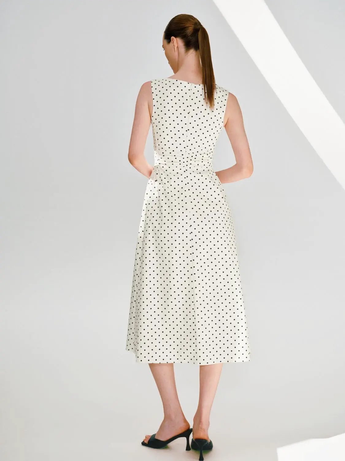 A-line dress, cream knit with black polka dots, sleeveless, back view.