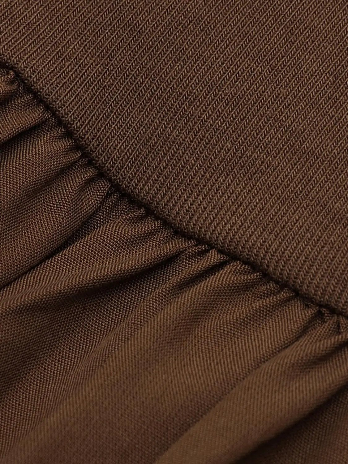 Dress, brown A-line fabric close-up with textured weave and pleated detailing.