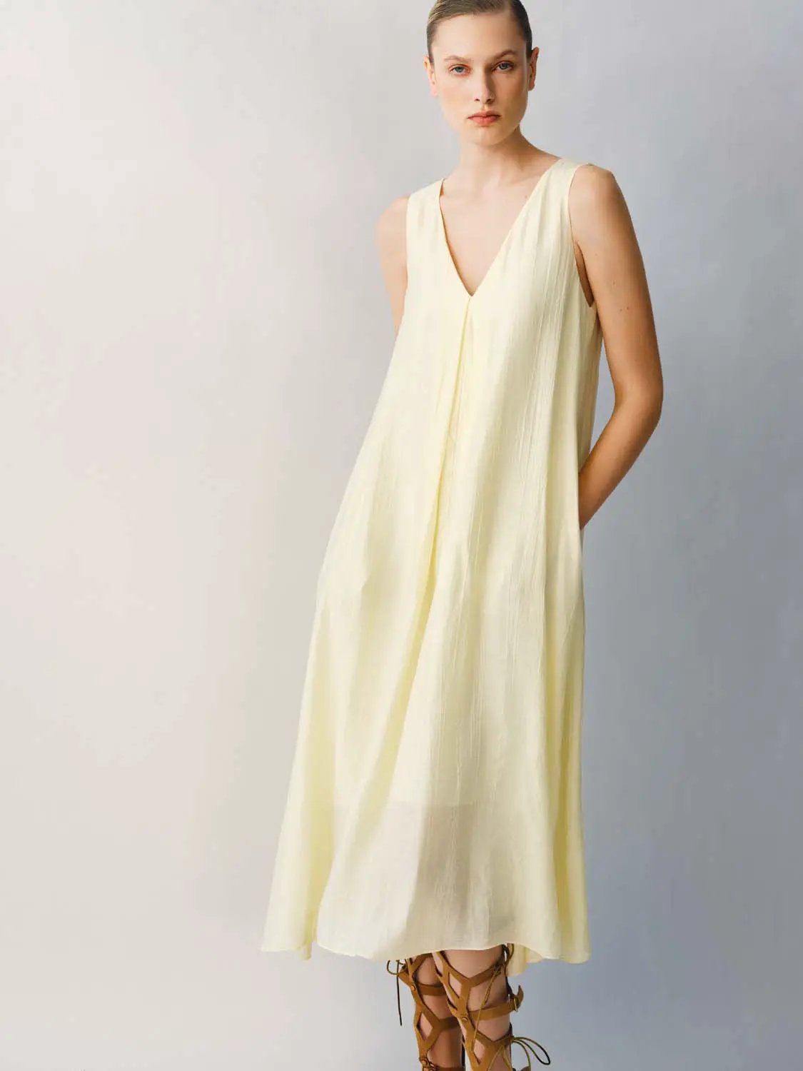 Slight-stretch A-line dress in pale yellow with lightweight fabric and a V-neck sleeveless bodice