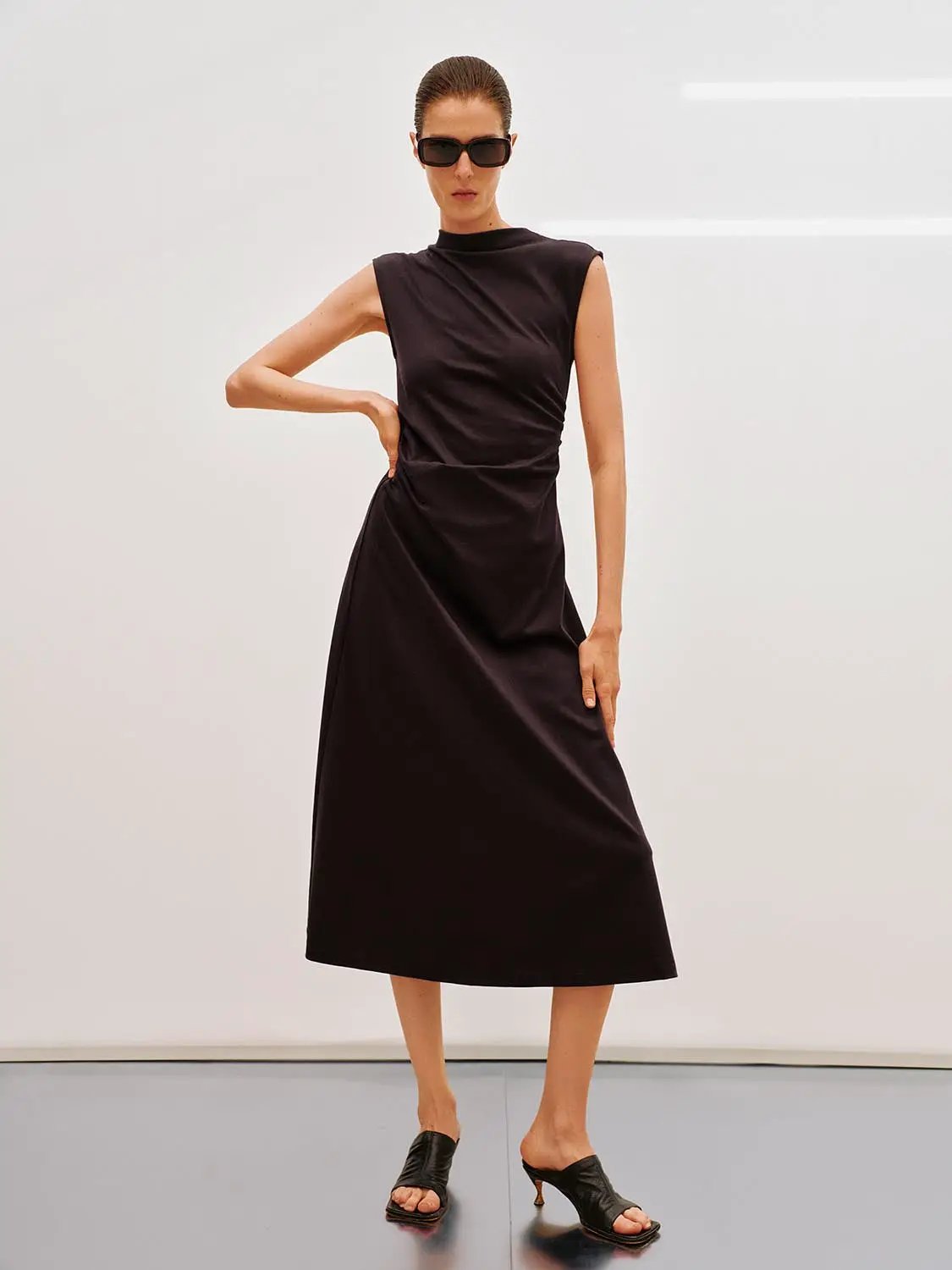 Dress, black sleeveless A-line midi dress worn by a model.