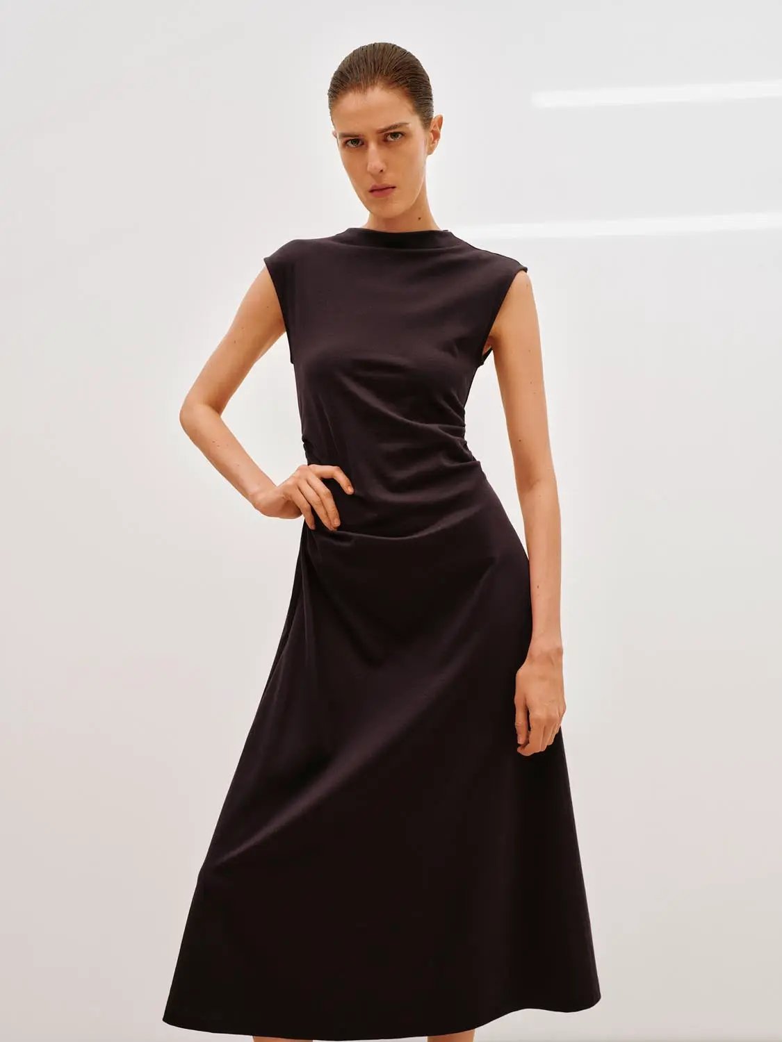 A-line dress in deep brown satin, sleeveless with high neckline, midi-length.