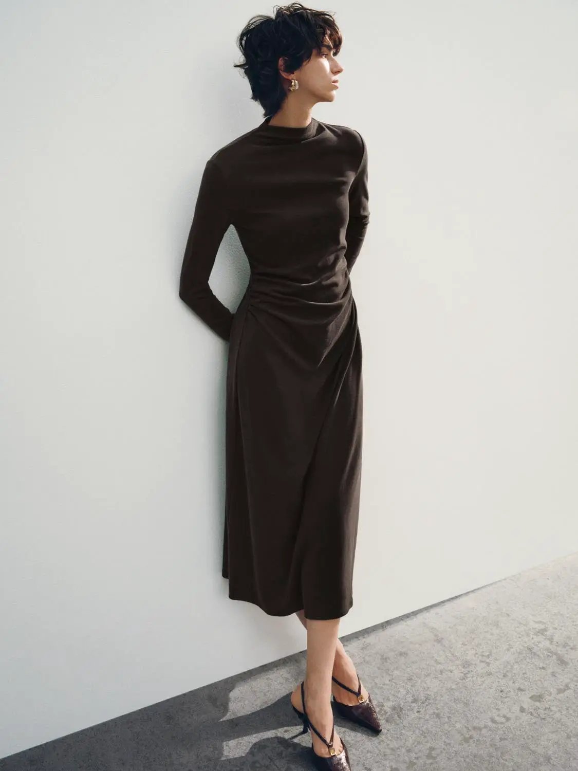 A-Line dress in chocolate brown with long sleeves and a draped waist, mid-calf length.