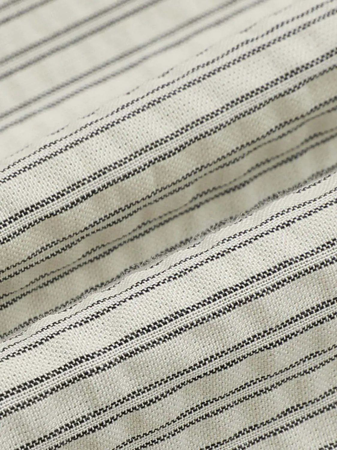 A-Line dresses fabric close-up in cream with narrow black pinstripes and woven texture details for upscale look