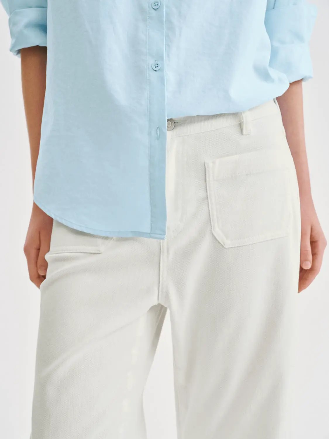 Casual wide-leg cotton-lyocell blend pants in white, paired with a light blue shirt.