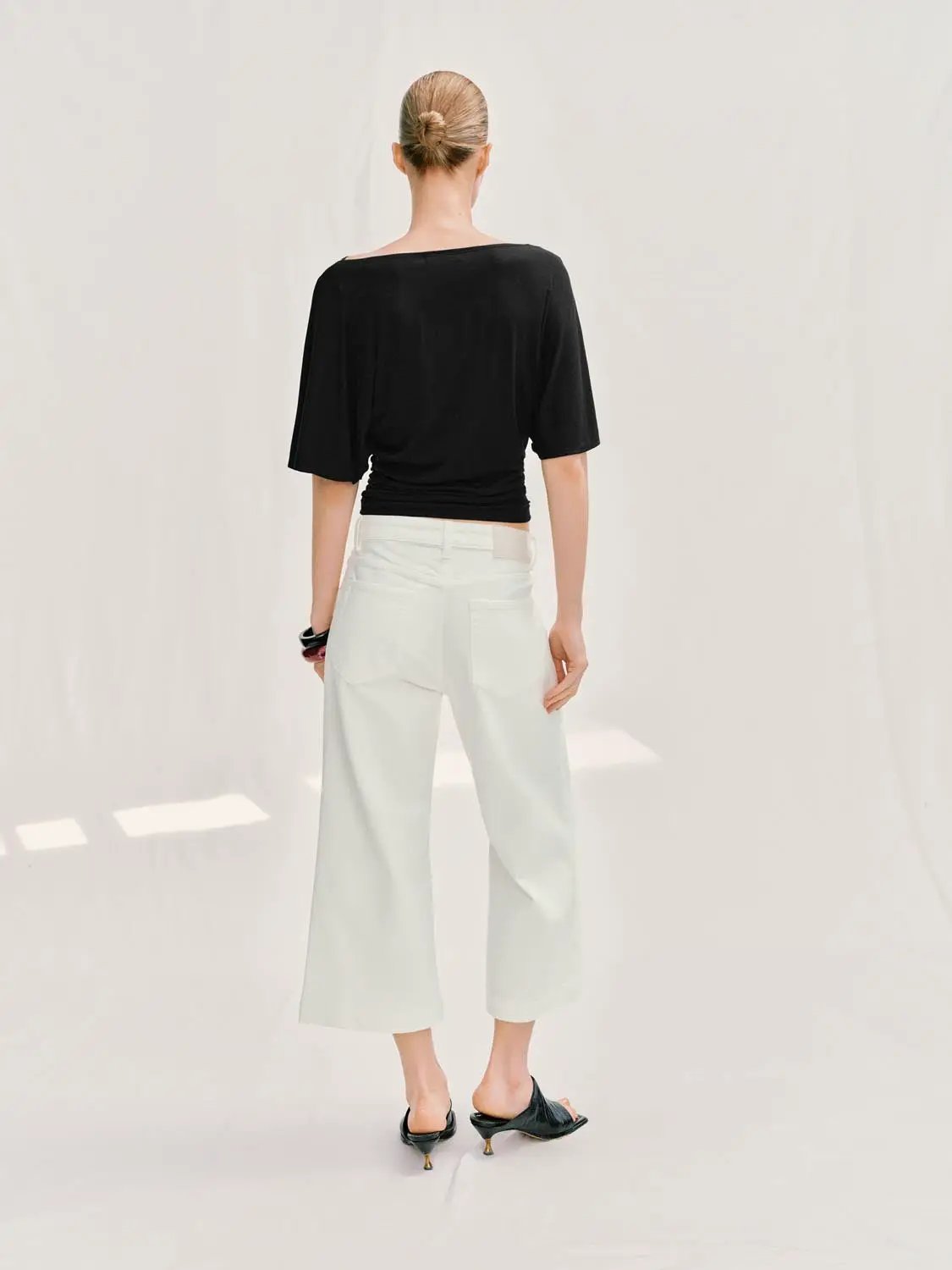 Casual Pants in white, cropped wide-leg jeans with back pockets, back view of model wearing a black top.