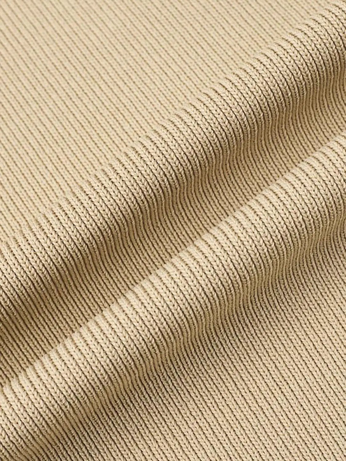 Knit vest close-up in beige ribbed fabric, cropped sleeveless style