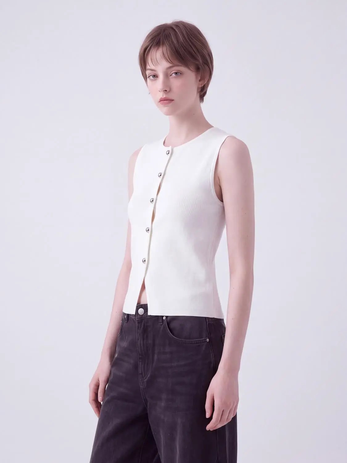 Round-neck white knit vest, sleeveless cropped with button-front placket.