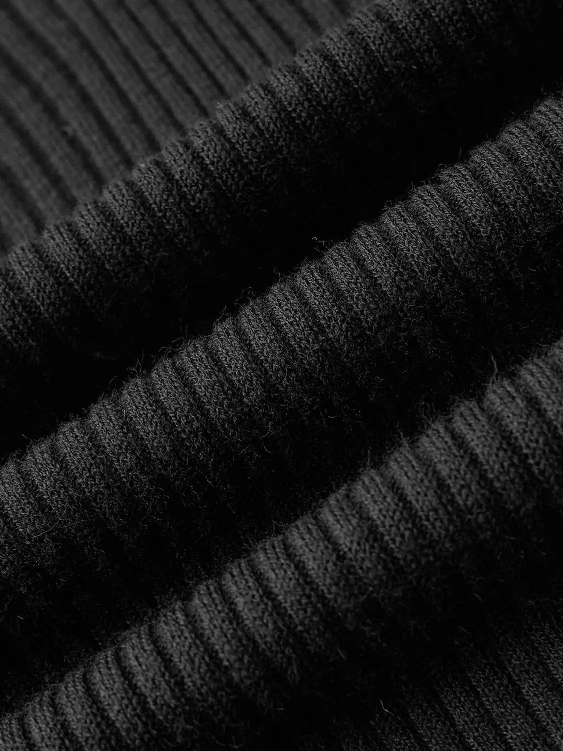 Knit T-Shirt fabric close-up in black with textured rib-knit material, showing soft fibers and woven stitches