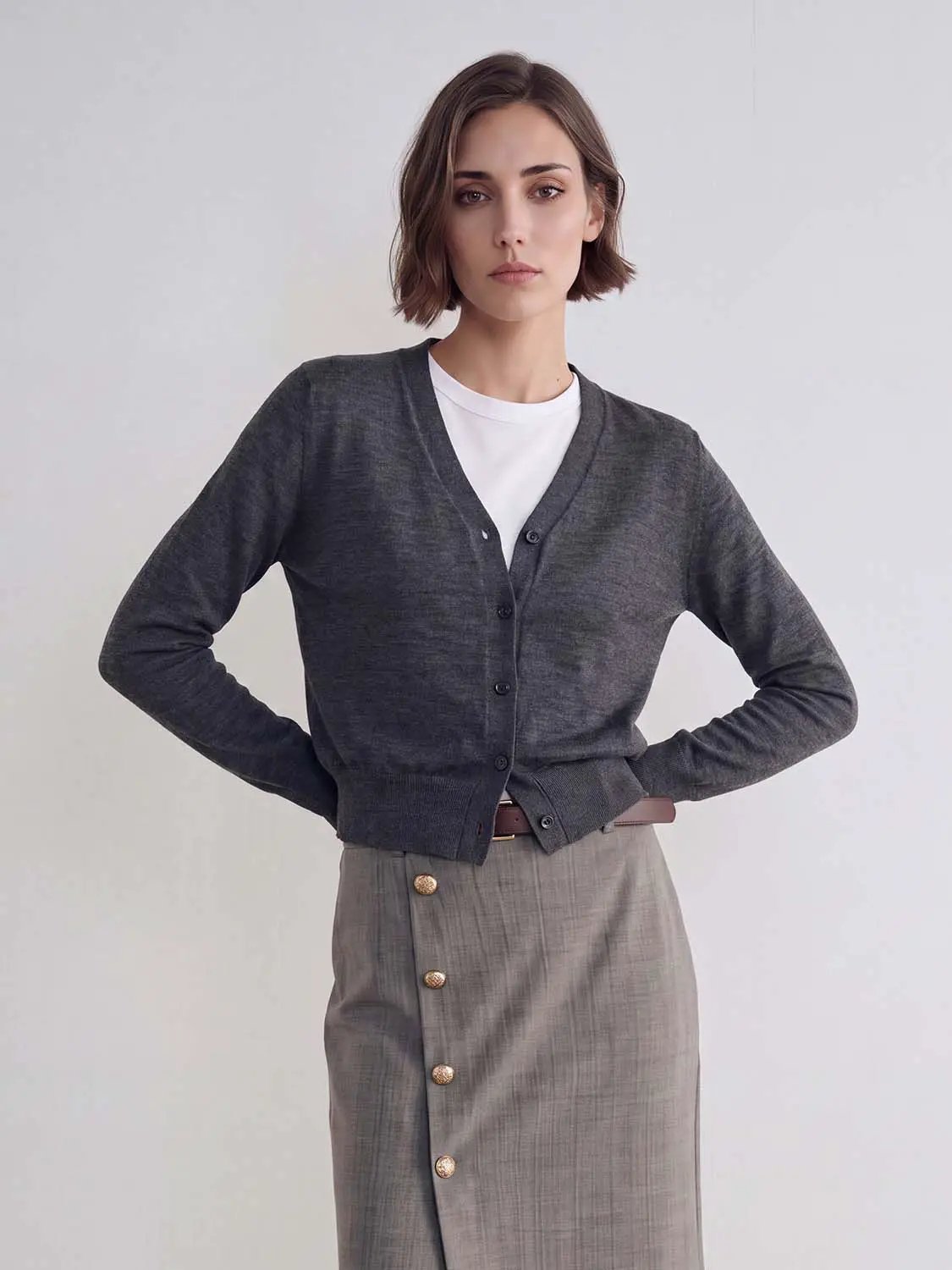 Knitted cardigan in dark gray by Urban Revivo Fashion, button-front, layered over white tee and taupe skirt with gold buttons.