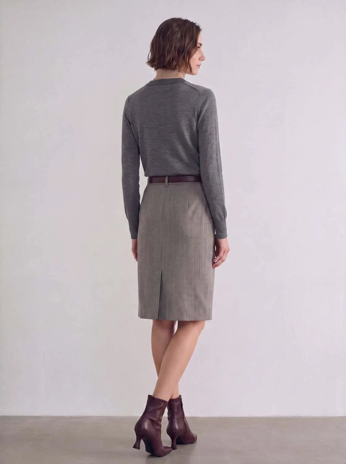 Knitted cardigan in gray worn with a gray pencil skirt and burgundy ankle boots