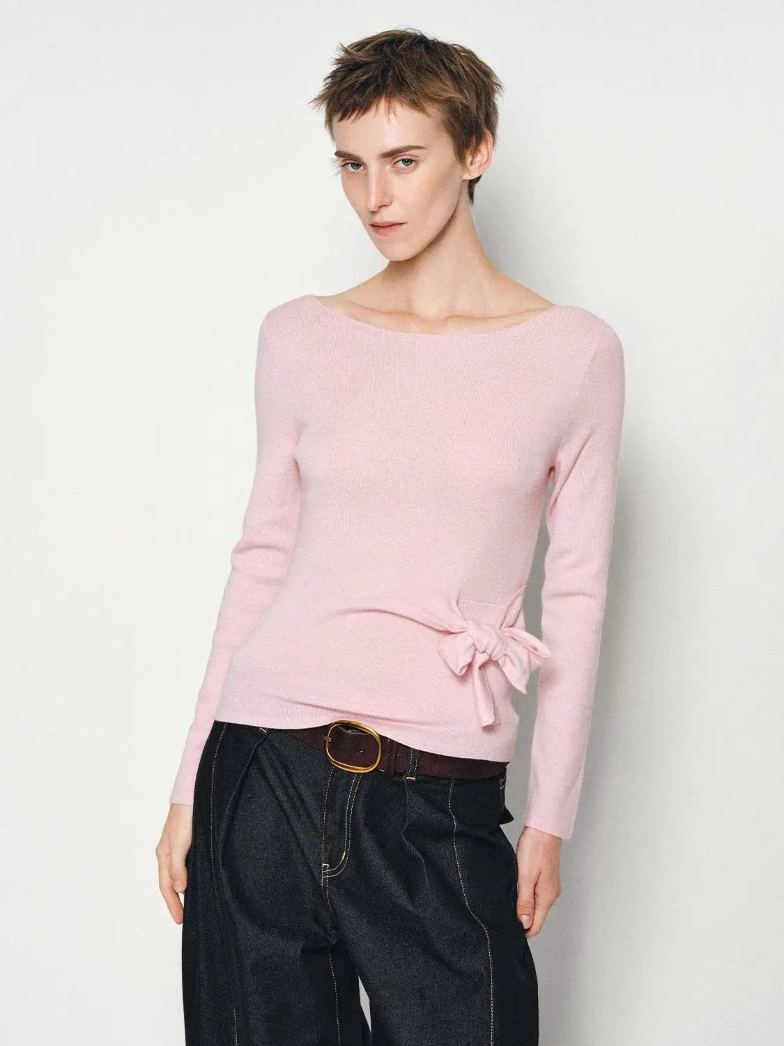 Ribbed pink knit top with boat neck, long sleeves, and side waist tie bow.