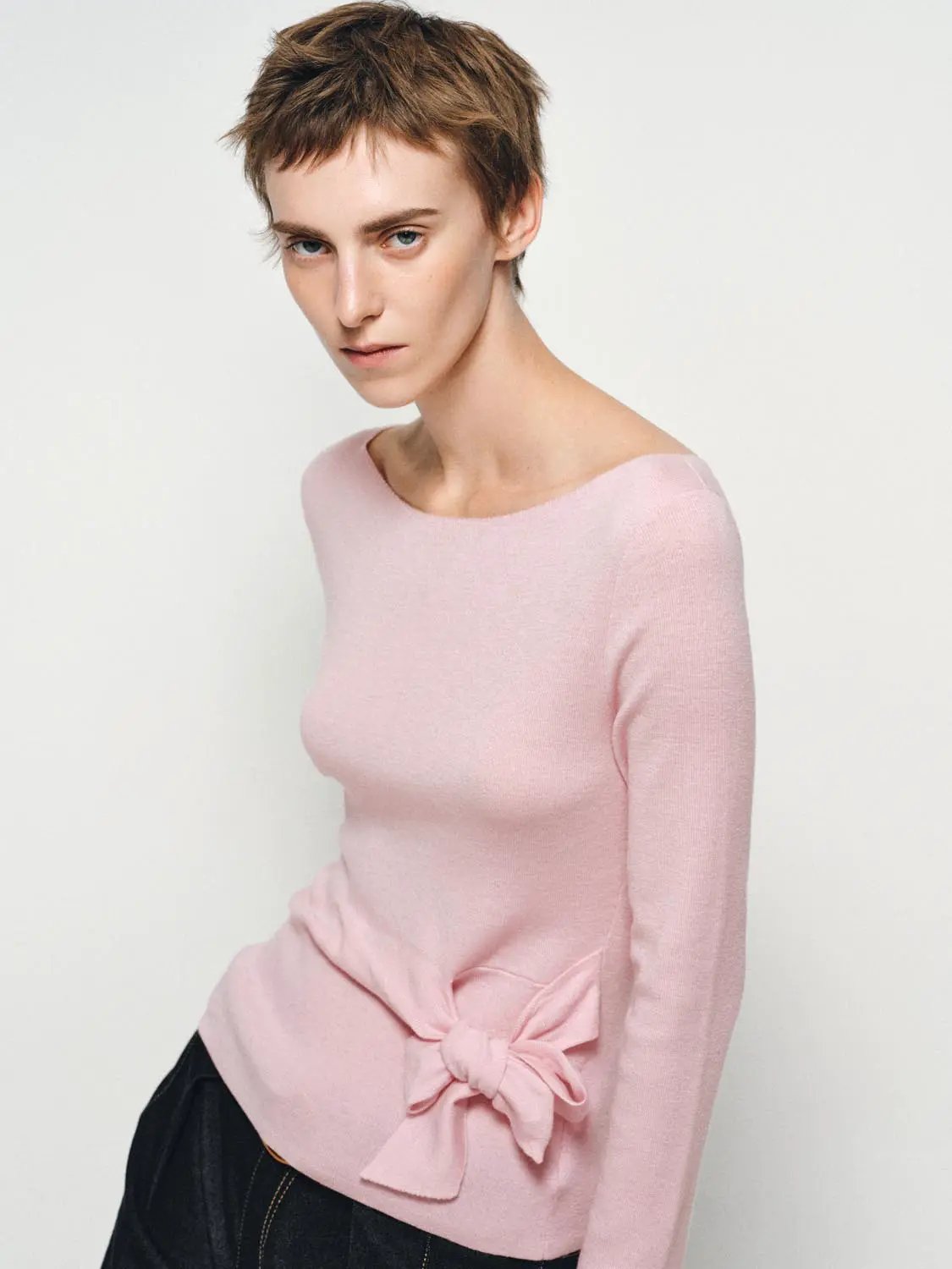 Ribbed long-sleeve boat-neck knit top in soft pink with a tie waist.