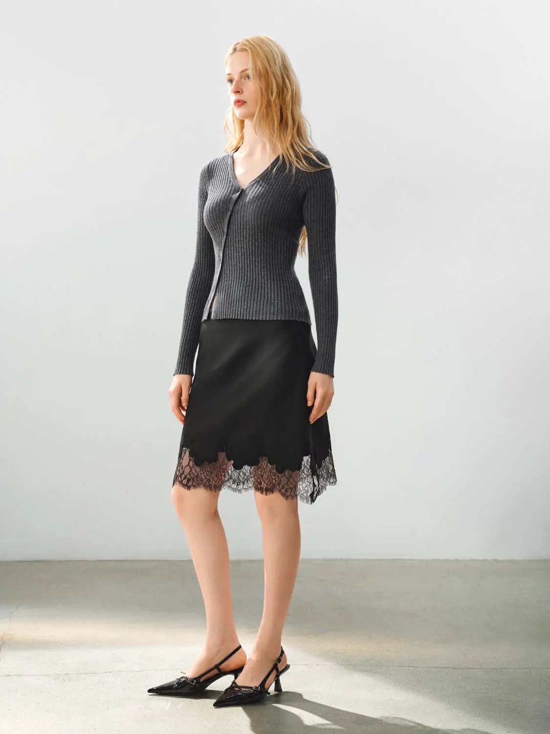 Fitted ribbed knit V-neck cardigan in gray paired with a black lace-hem skirt