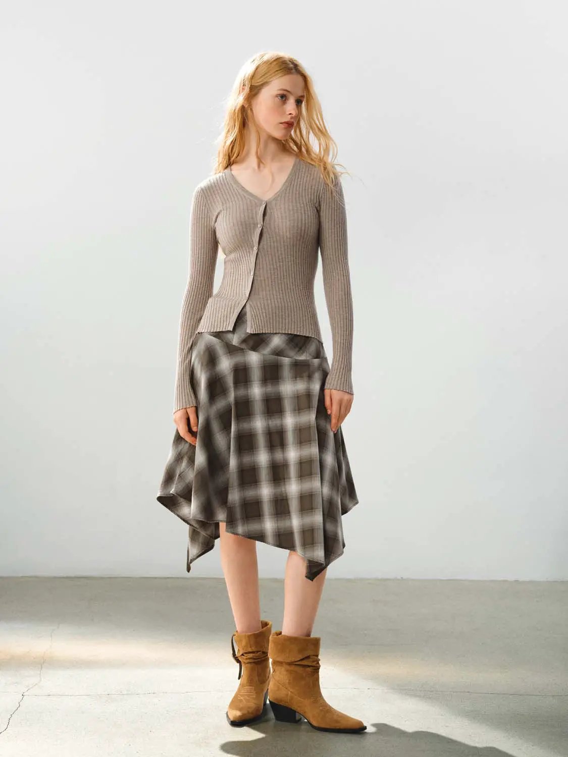 Fitted ribbed knit V-neck long-sleeve cardigan in beige; three-piece outfit with plaid skirt and tan boots
