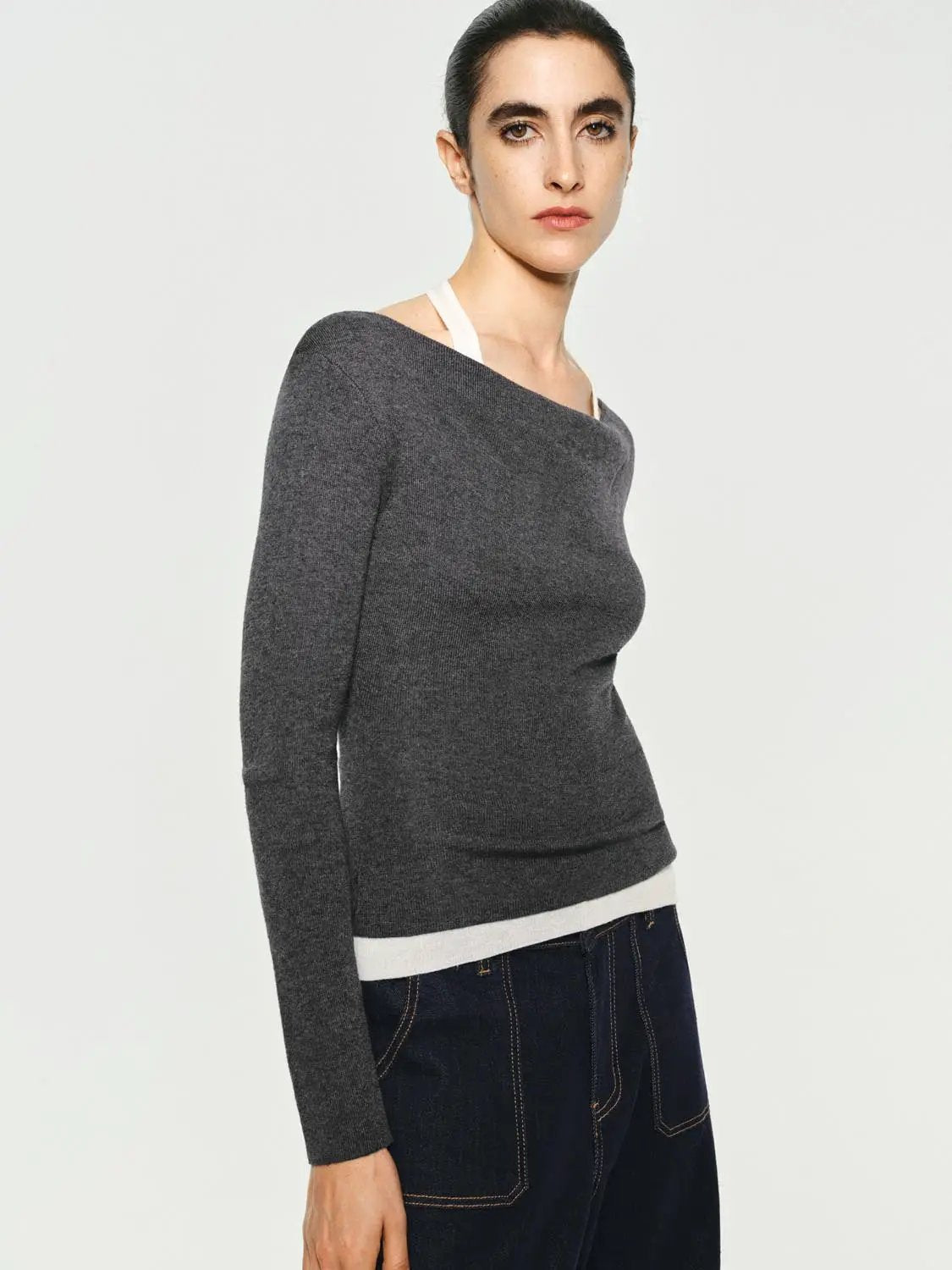 Fitted contrast-hem boat-neck long-sleeve knit top in gray with white hem, worn by a model