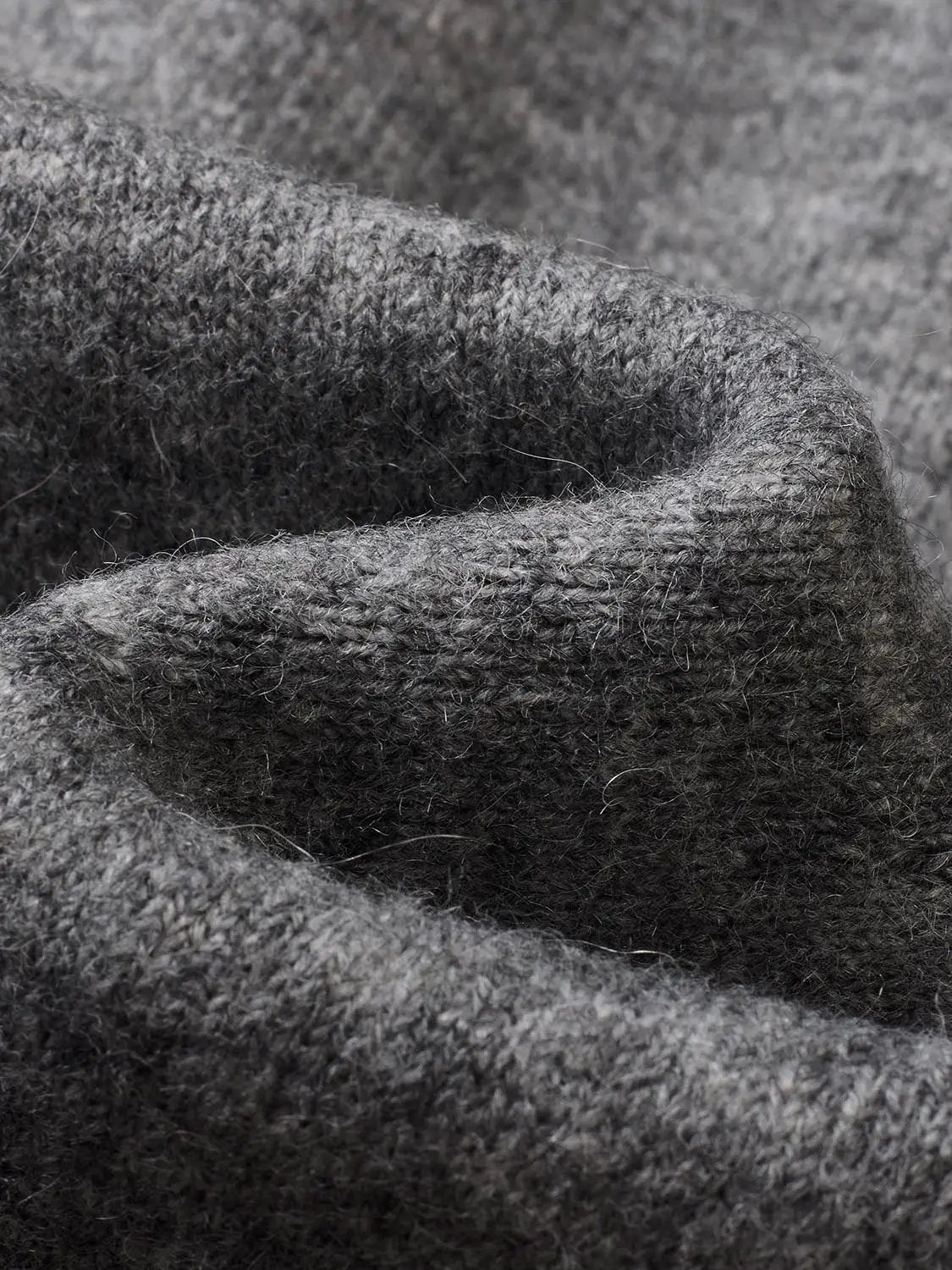 Gray knitted cardigan fabric close-up with a soft, textured knit