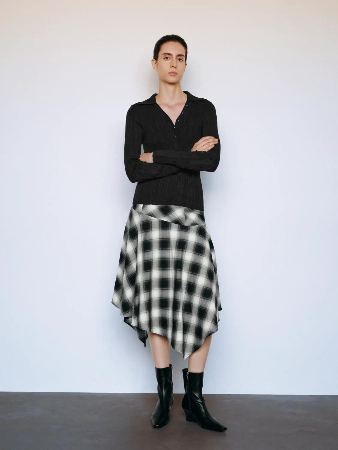 Ribbed fitted polo-collar long-sleeve sweater, black, with a black-and-white plaid skirt; two-piece outfit