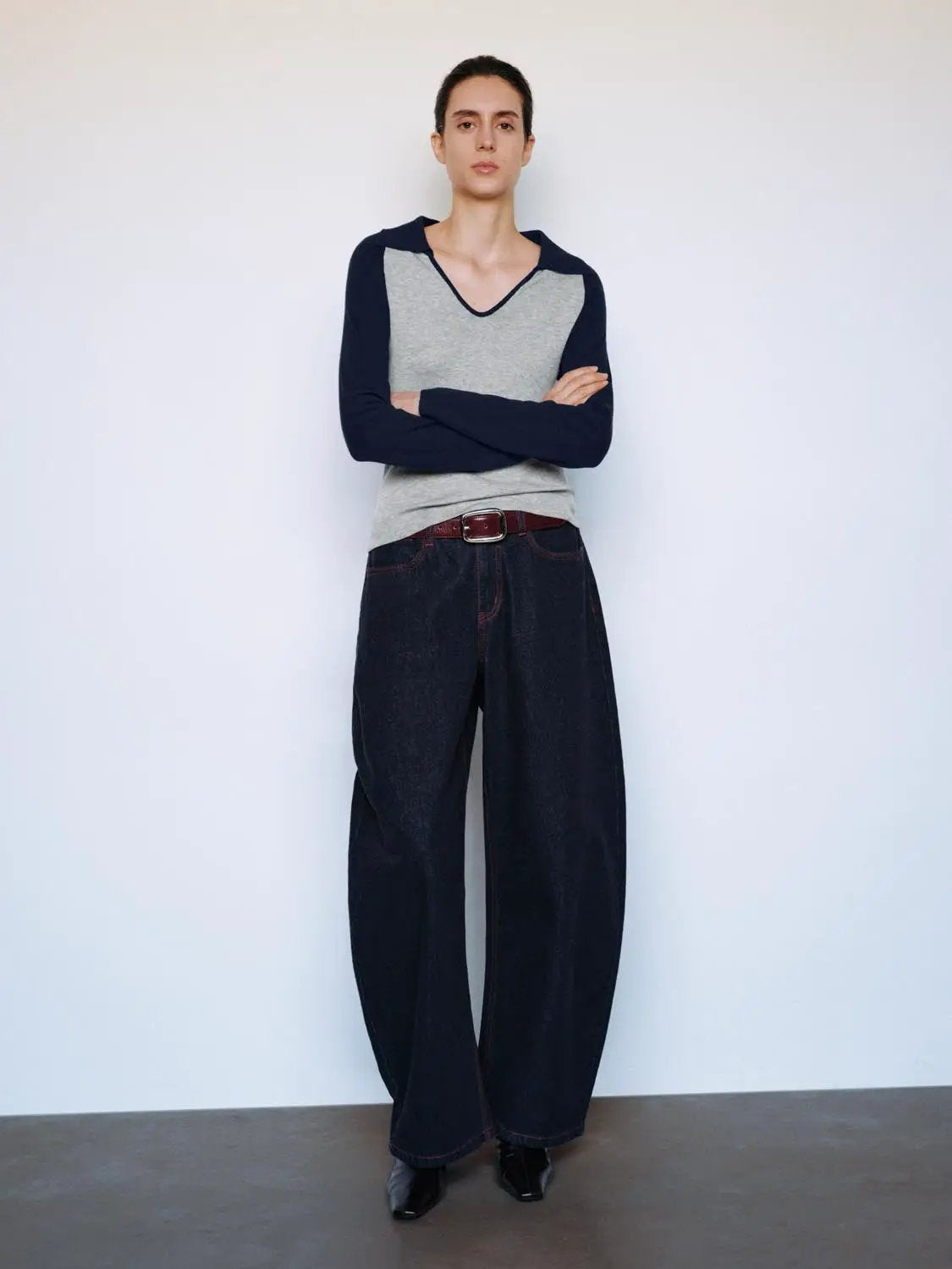 Fitted two-tone V-neck collared long-sleeve knit top with gray front panel and navy sleeves.