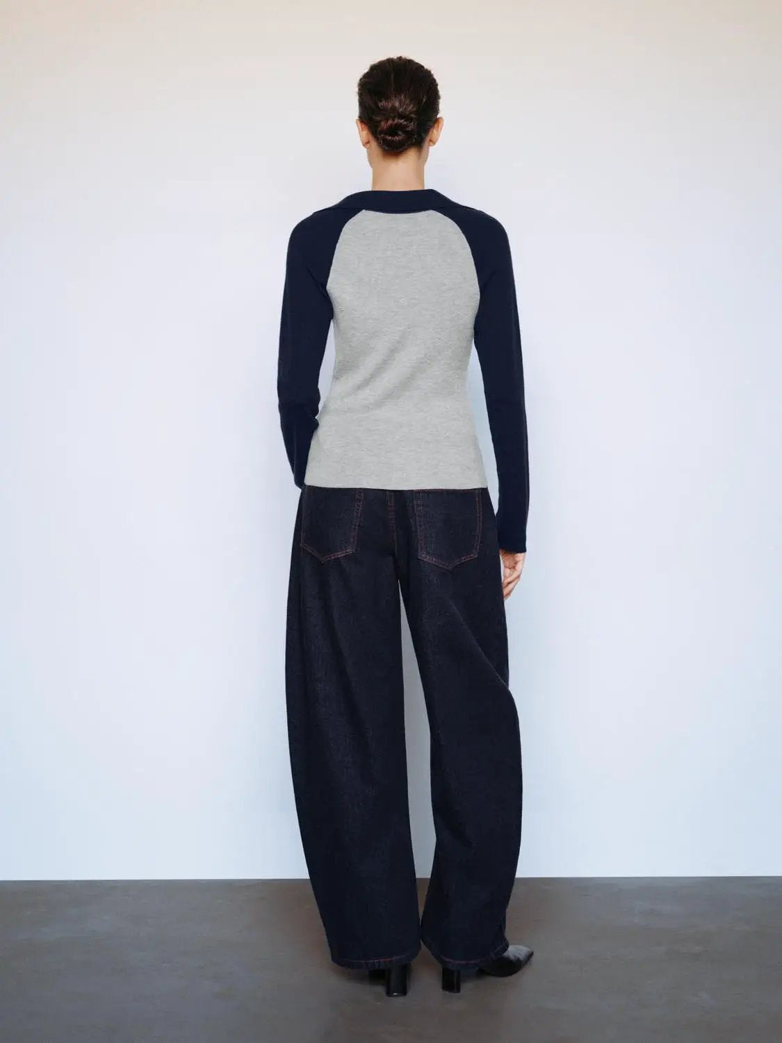Fitted two-tone V-neck collared knit top, navy long sleeves with light gray body, back view.