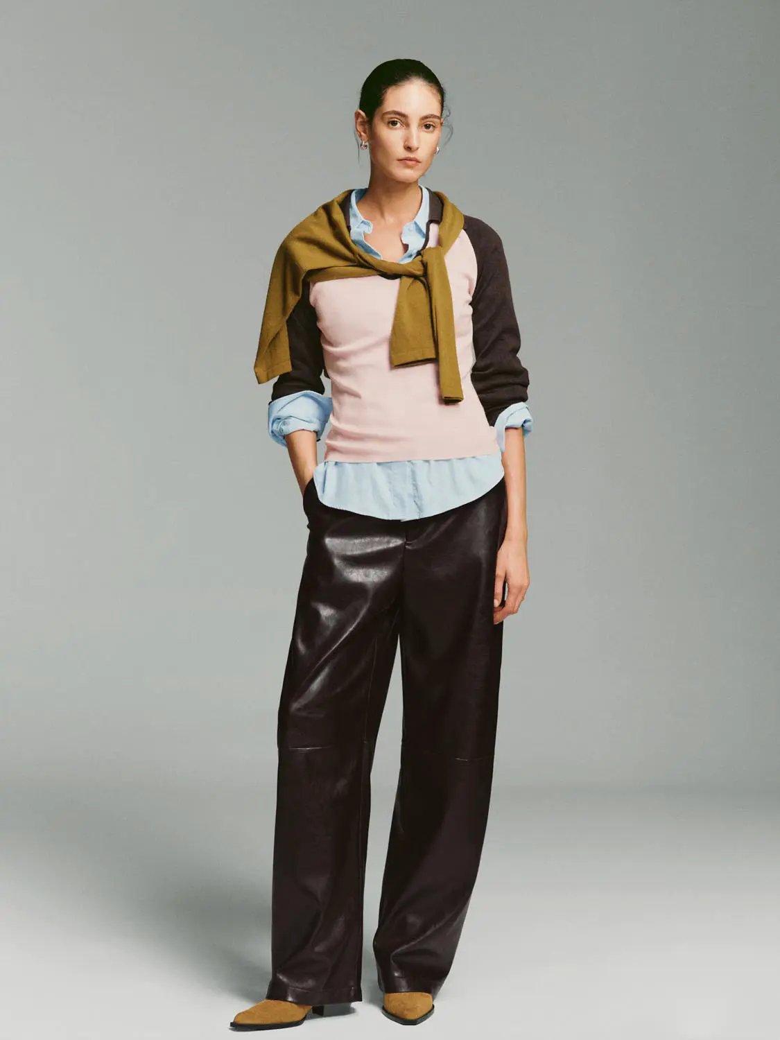 Fitted two-tone V-neck collared knit top in pink with brown sleeves, layered over blue shirt and mustard scarf