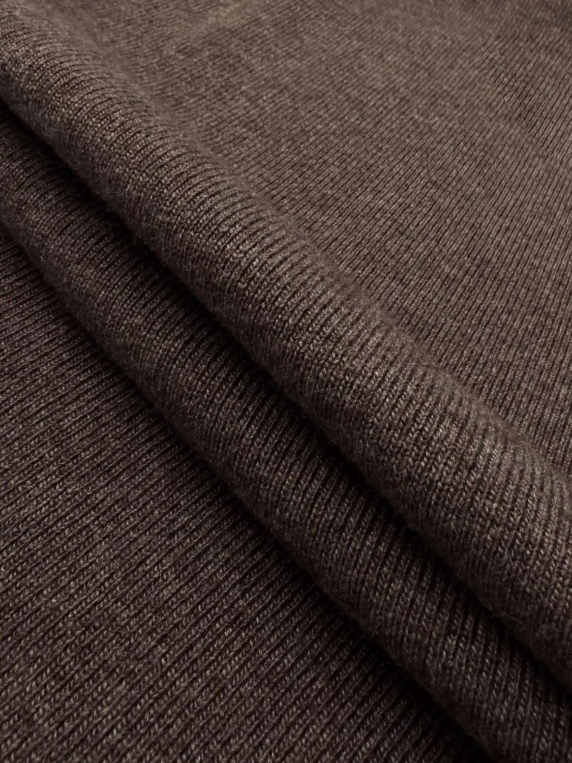 Knitted T-shirt fabric in brown with visible rib-knit texture.