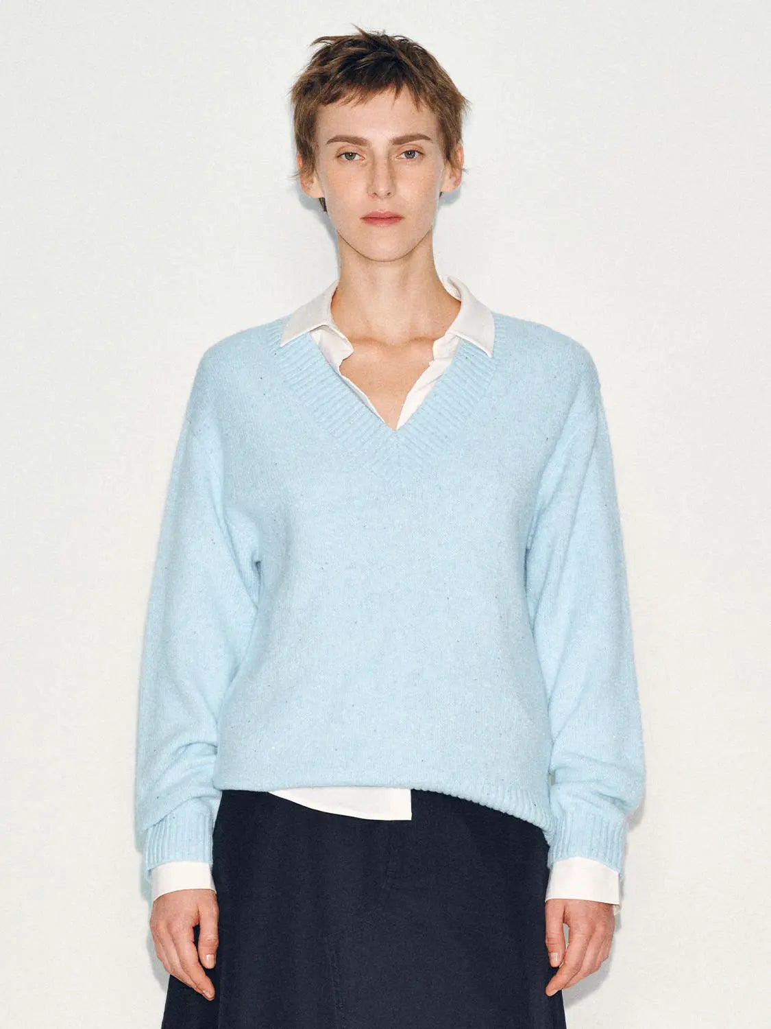Knitted T-Shirt in light blue, layered over a white shirt.