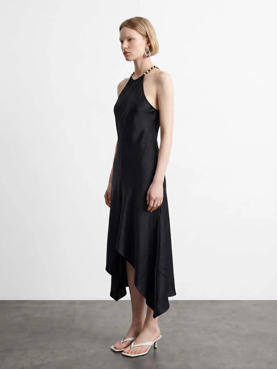 A-Line dress by Urban Revivo Fashion in black satin with halter-neck and high-low hem.