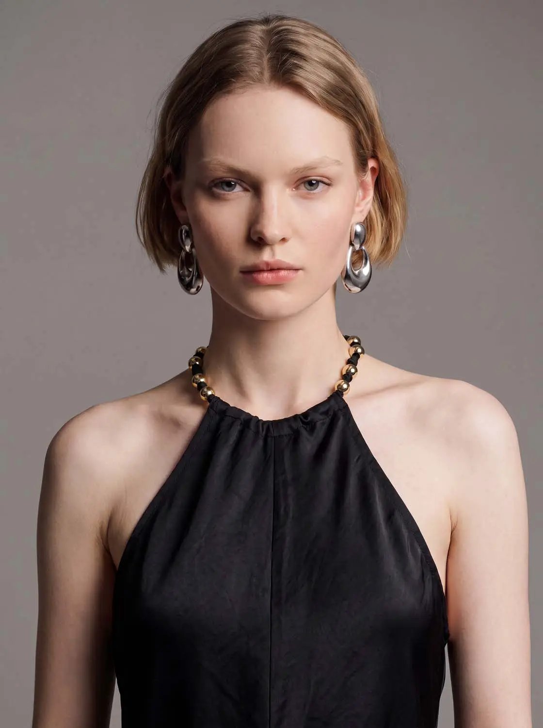 A-Line dress, black halter-neck style on a model with silver hoop earrings