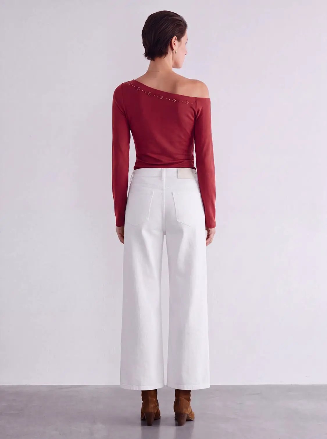 High-rise belted wide-leg cotton jeans in white, back view.