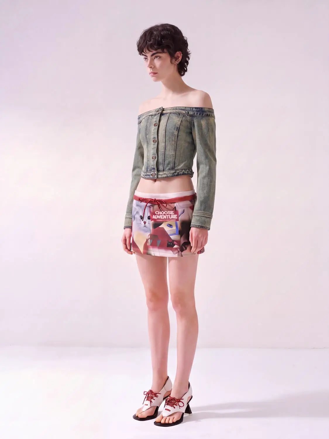 Long sleeve off-shoulder washed denim cropped top with front buttons; two-piece outfit with a colorful printed mini skirt