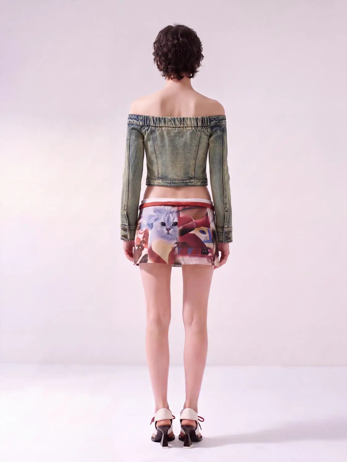 Long sleeve off-shoulder washed denim cropped top; blue denim with buttoned cuffs.