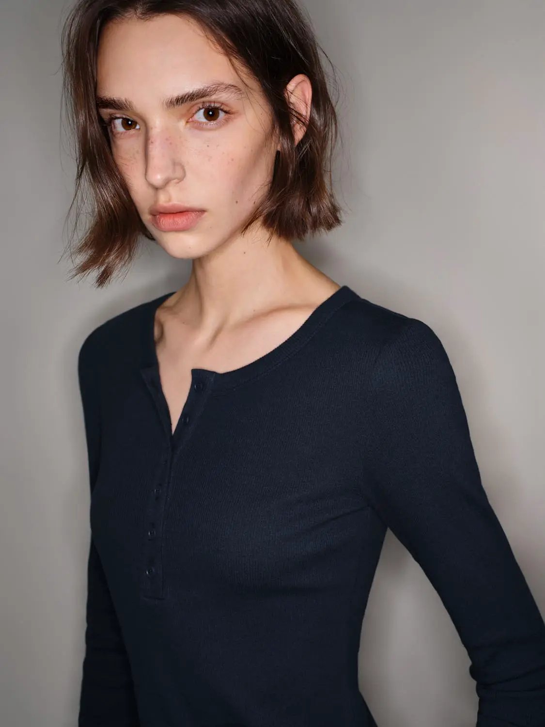 Navy long-sleeve knit T-shirt with button placket on model