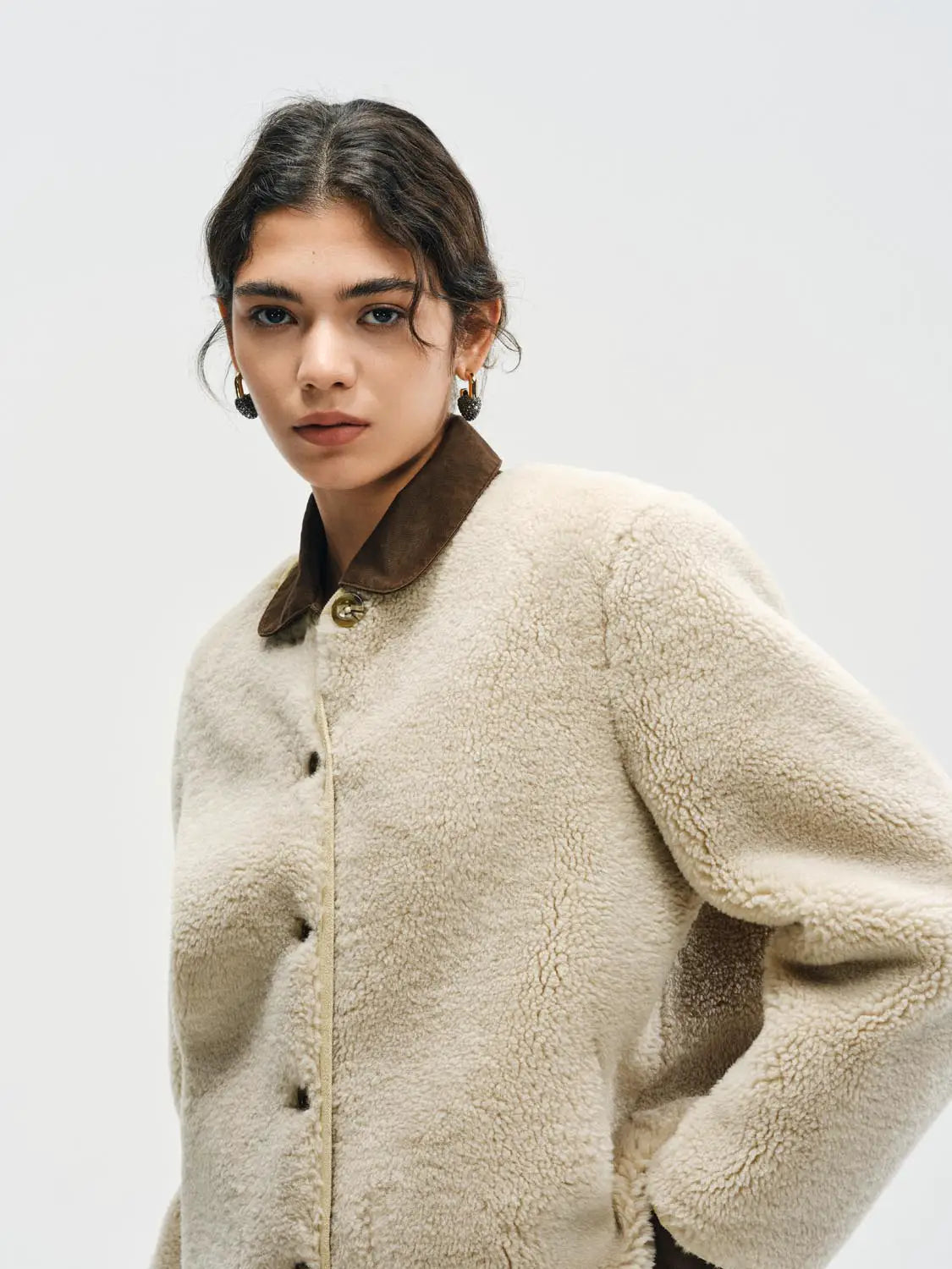 Jacket: beige shearling fur coat with brown suede collar and gold button closure.