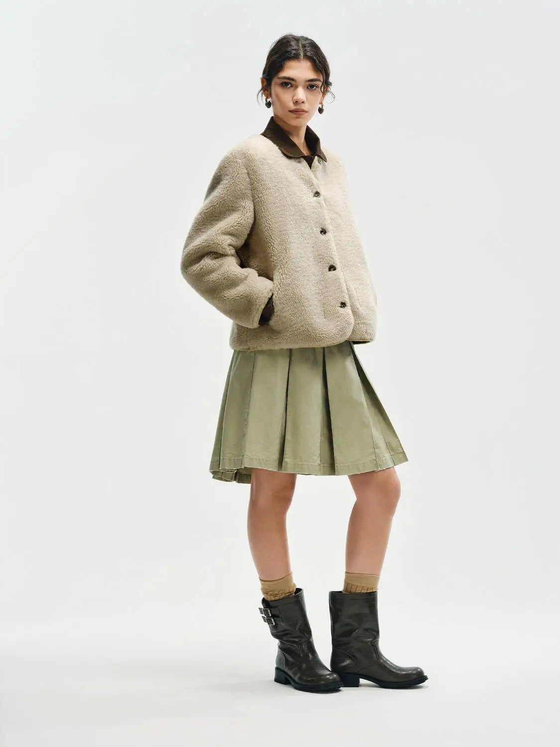 Jacket in beige teddy fur with brown collar and dark buttons.